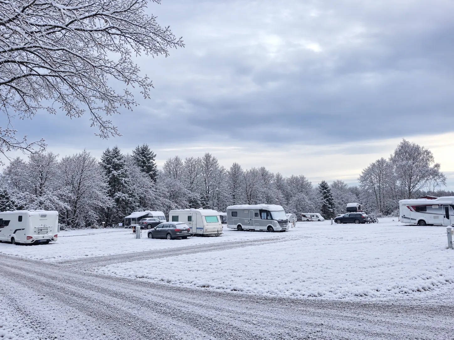 Husbilar och husvagnar på snötäckta campingplatser på Bergby.