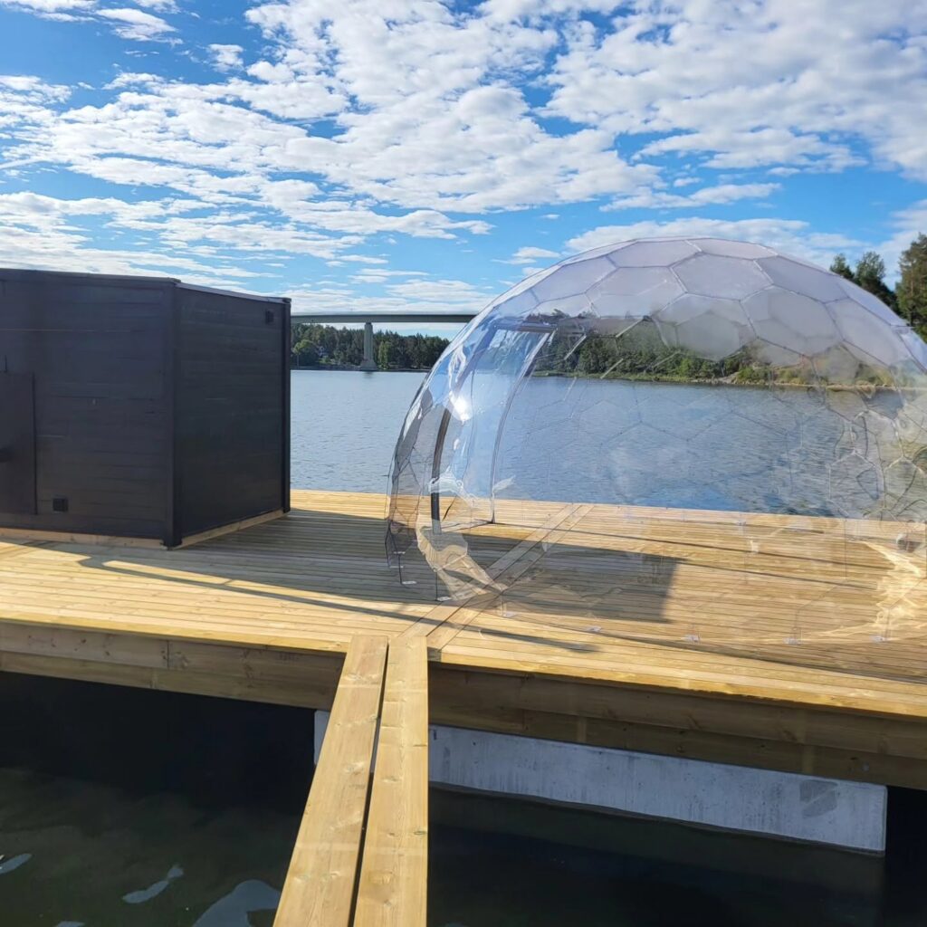Bryggan med bastun och tillhörande avkopplingsplats. Väddöviken med Trästabron i bakgrunden.